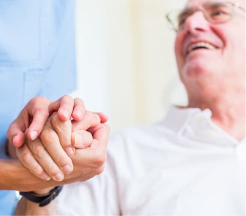 Carer and patient holding hands